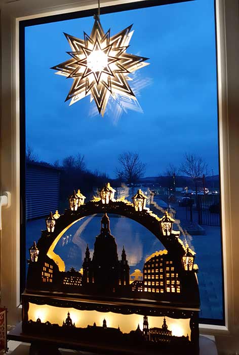 Fenster mit beleuchtetem Stern und Schwibbogen